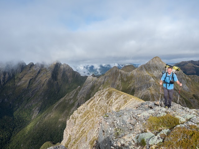 Wanderer auf Grat mit steilem Bergkamm der "Dragons Teeth" im Hintergrund in Neuseeland