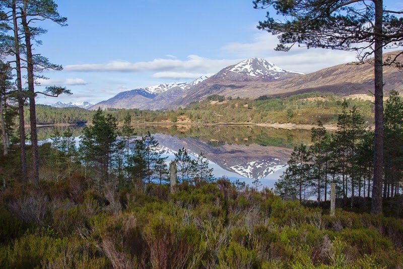 Spiegelung eines Berges mit Schnee im Wasser in Schottland