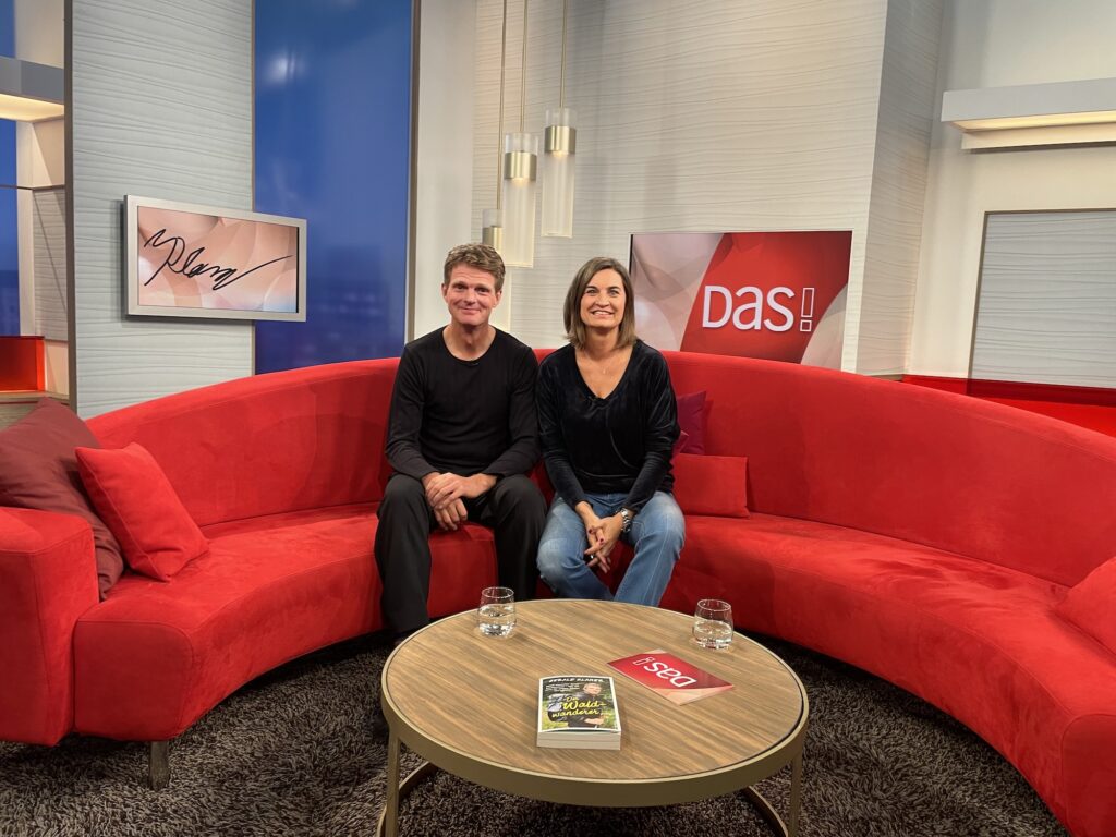 Gerald Klamer sitzt mit der Moderatorin Inka Schneider von DAS! auf dem Roten Sofa des NDRs